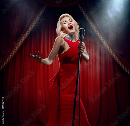 The singer in a luxurious dress on the cabaret stage.