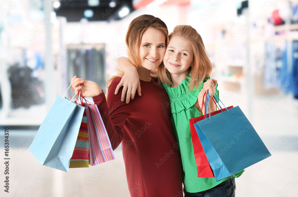 Mother and daughter with paper bags on white background Mother and daughter with paper bags on white background