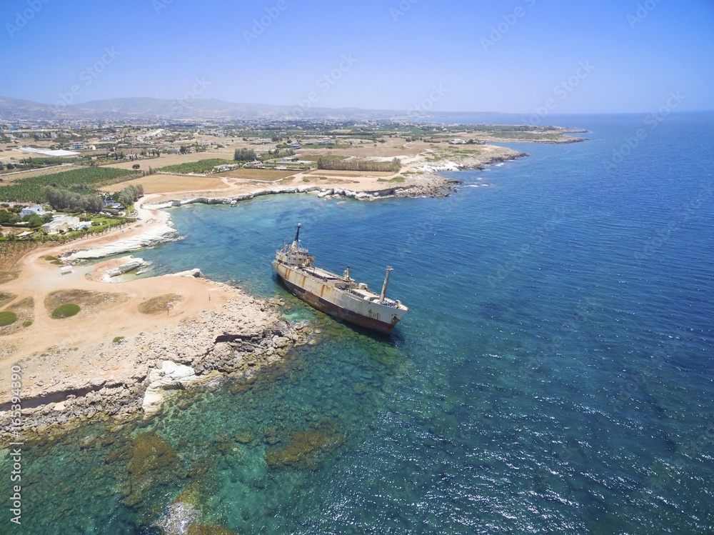 Aerial view of abandoned ship wreck EDRO III in Pegeia, Paphos, Cyprus. The rusty shipwreck is stranded on Peyia rocks at kantarkastoi sea caves, Coral Bay, Pafos, standing at an angle near the shore.