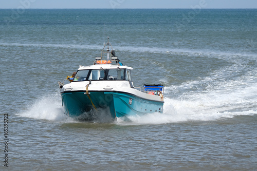 Shell fishing boat returning to shore with catch. © Paul