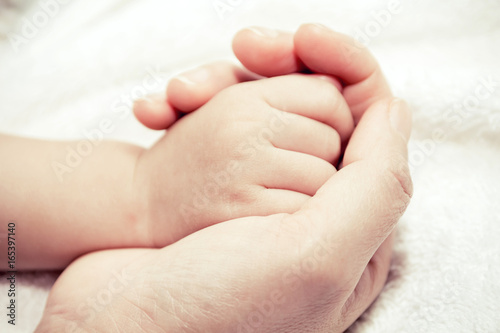 Mother holding hand of a baby