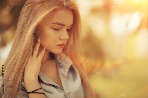 portrait of a beautiful young blonde woman with sun rays and glare