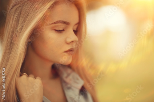 portrait of a beautiful young blonde woman with sun rays and glare