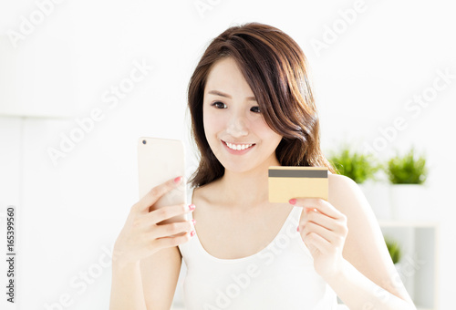 woman buying online with credit card and smart phone