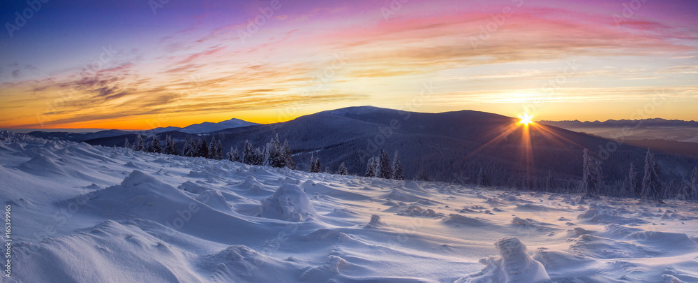 Kolorowy wschód słońca nad górami w zimowy poranek