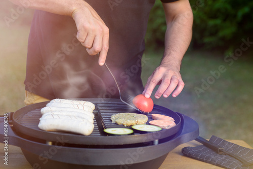 Unrecognisable man using electric grill. Garden grill party, summer barbecue concept