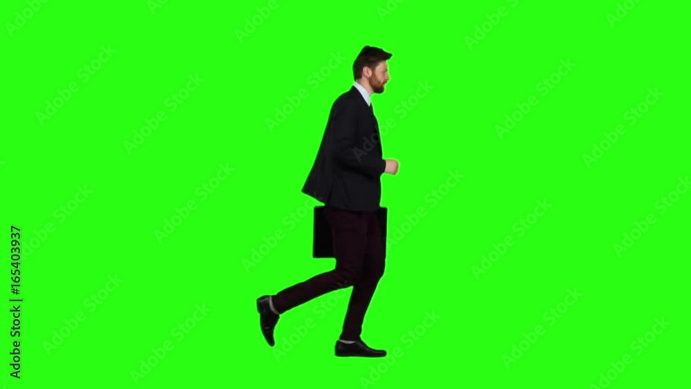 Man is running a briefcase in his hand, he rushes over it. Green screen. Slow motion