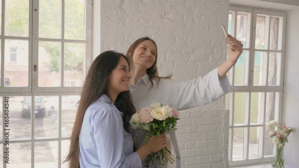 beautiful young girlfriends taking selfie with bouquet at studio beautiful young girlfriends taking selfie with bouquet at studio