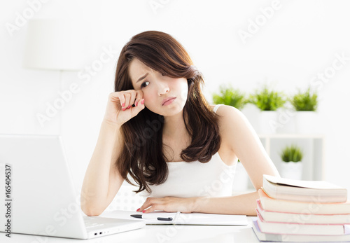 tired female student studying with laptop