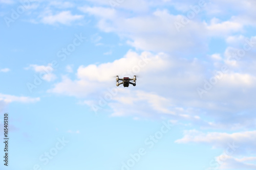 Quadcopter with camera flying on a clear sunny sky sunset background with nice lens flare.
