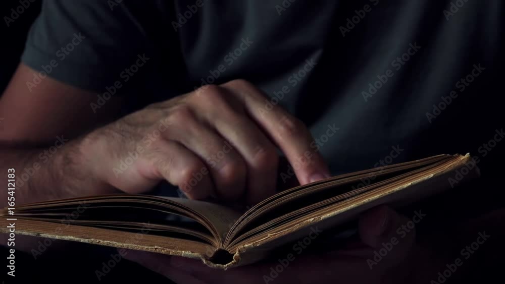 Man reading old book at home