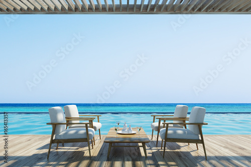 White armchairs and table near a pool