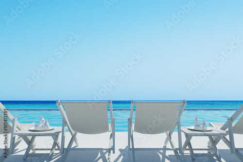 White deckchairs and a table  rair view