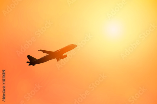 air plane is Flying and sun lighting in the orange sky