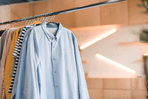 close-up view of various stylish clothes hanging on hangers in boutique