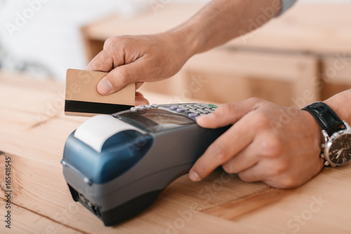 close-up partial view of man making payment by credit card and terminal