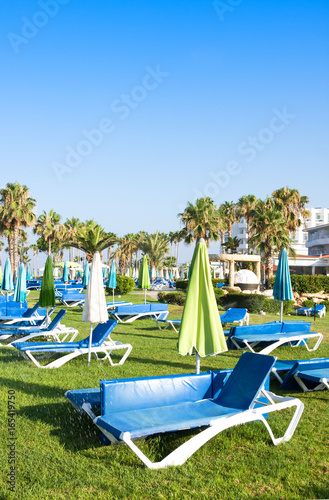 Mediterranean palm beach with empty sunbeds in morning, Paphos, Cyprus
