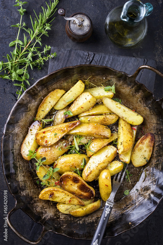 Bratkartoffel mit Kräuter als top view in Eisenpfanne
