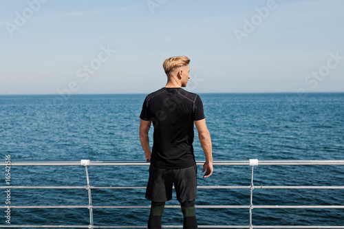 Sportsman posing on waterfront 