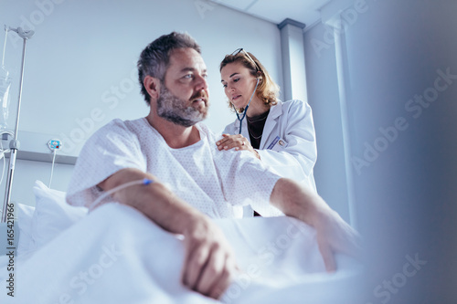Hospitalised man getting examined by female physician