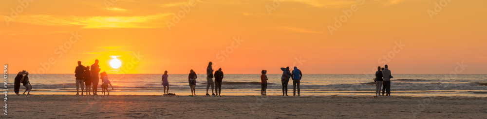 Strandurlaub an der Nordsee, Urlauber genießen den Sonnenuntergang Strandurlaub an der Nordsee, Urlauber genießen den Sonnenuntergang