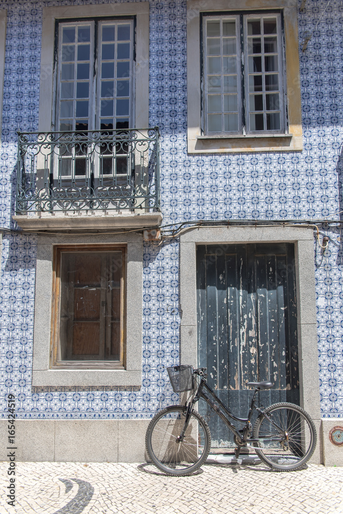 Portugal, typical facade with blue azulejos, with a bike 
