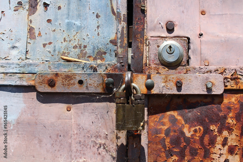 A closeup shoot of an old an rusty garage door with padlock