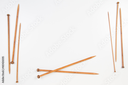 Wooden knitting needles frame with copy space for text on white background