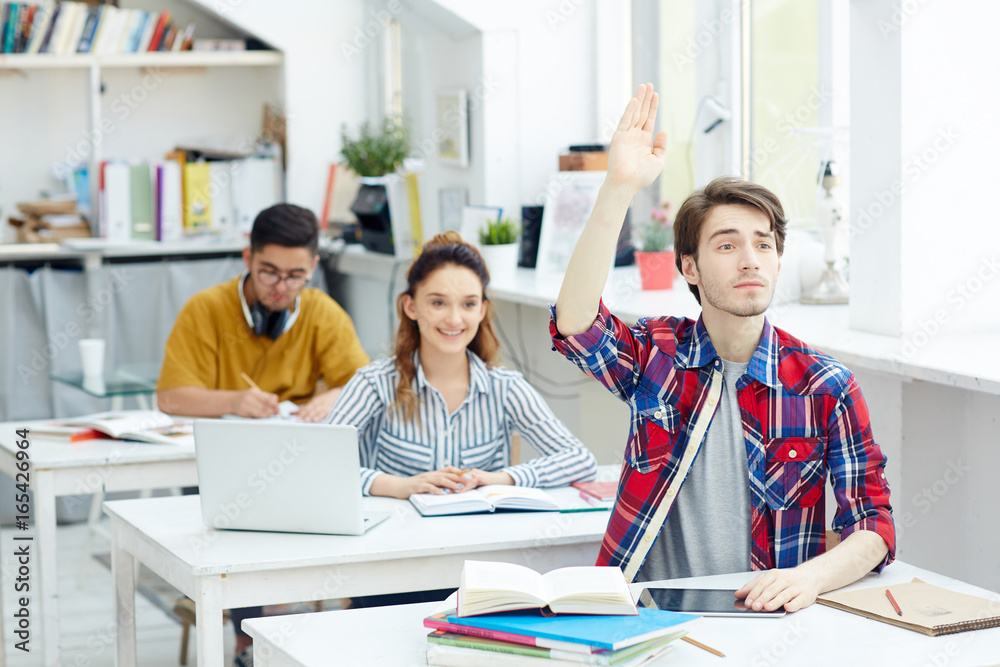 Fototapeta premium Clever guy raising his hand at lesson