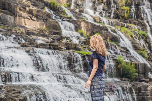 Young woman hiker, tourist on the background of Amazing Pongour Waterfall is famous and most beautiful of fall in Vietnam. Not far from Dalat city estimate 45 Km. Dalat, Vietnam photo