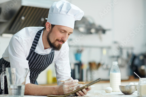 Young chef making notes in notepad