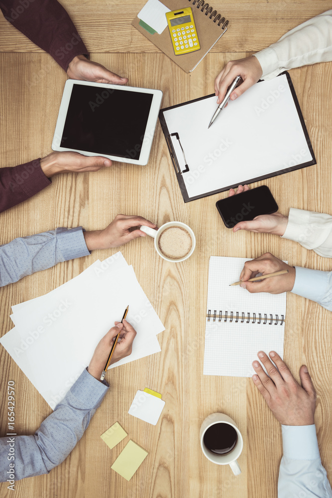 top view of businesspeople on meeting with documents and digital tablet at workplace top view of businesspeople on meeting with documents and digital tablet at workplace