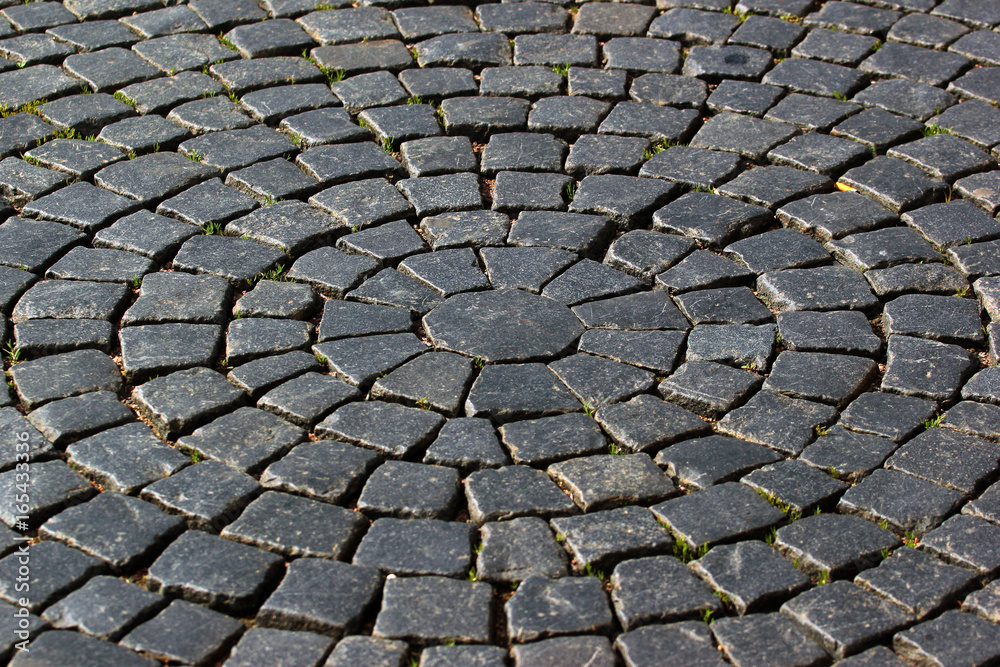Radial pavement pattern. Background of black cobblestones Radial pavement pattern. Background of black cobblestones