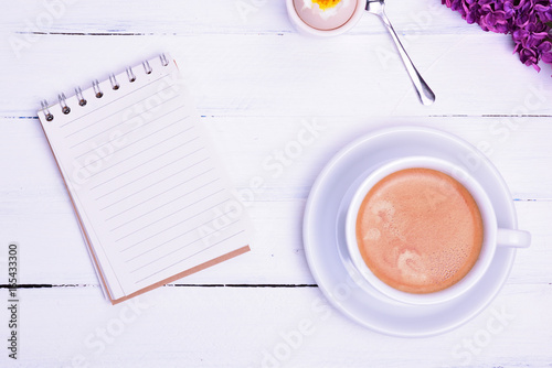 Empty paper notebook and cup of coffee