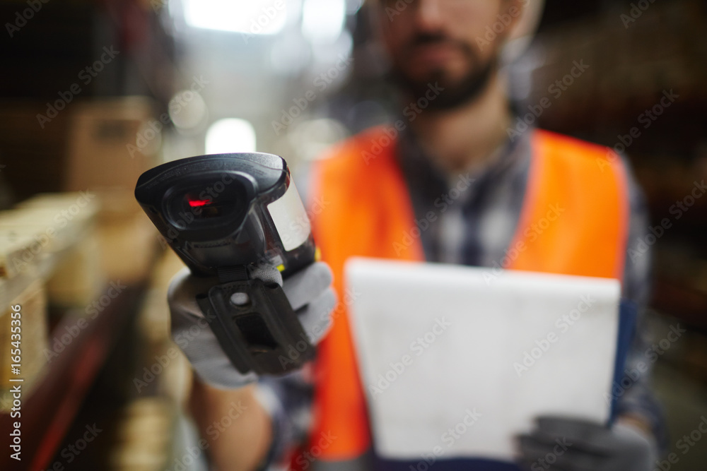 Closeup of bar code scanner in hand of unrecognizable warehouse worker doing inventory of stock Closeup of bar code scanner in hand of unrecognizable warehouse worker doing inventory of stock