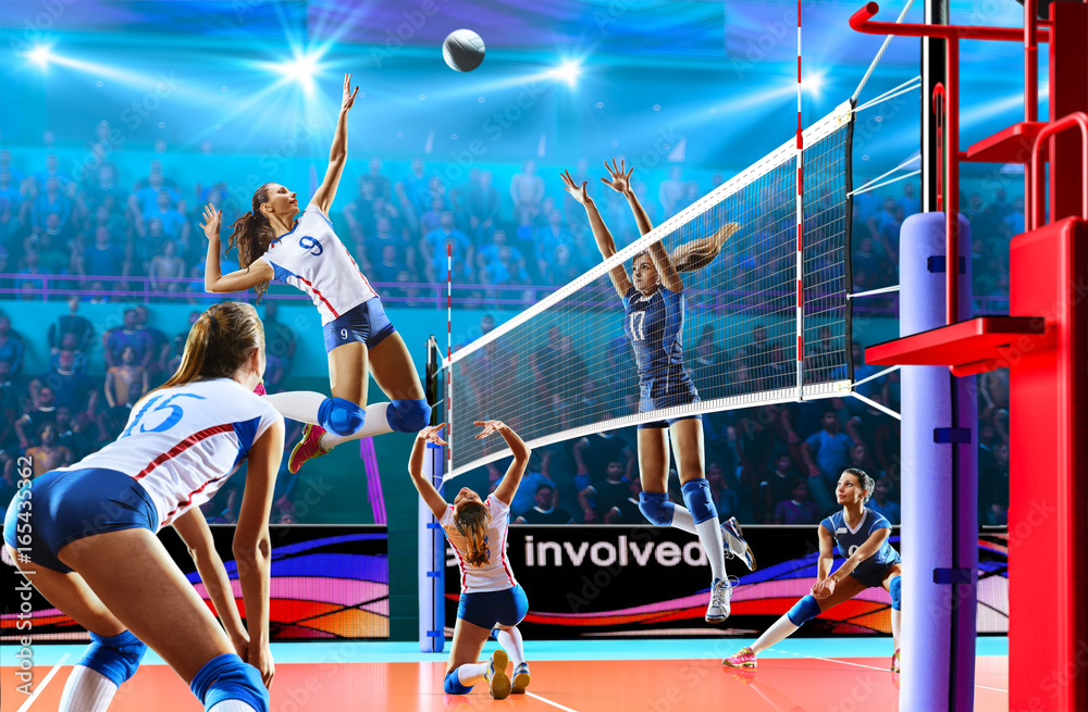 Female professional volleyball players in action on grand court Stock