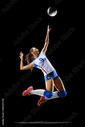 Female professional volleyball player isolated on black