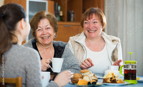 Young female and mature women drinking tea and talking