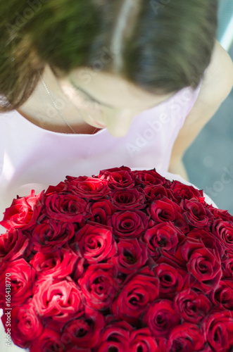 Girl and flowers Hands and roses The girl is holding a bouquet of roses Fragment Top view photo