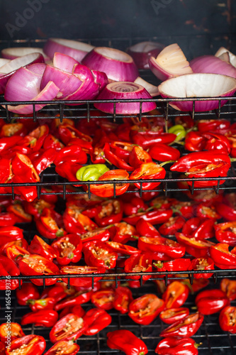 Red onions, habaneros, and jalapeno peppers being smoked