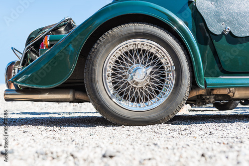 spoked rear wheel of a green morgan +8 cabriolet - oldtimer