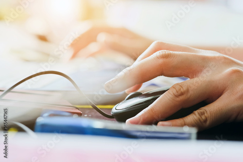 Close-up of female hands using laptop computer, working on laptop with flare light background. Searching Internet ,Businesswoman working at home office