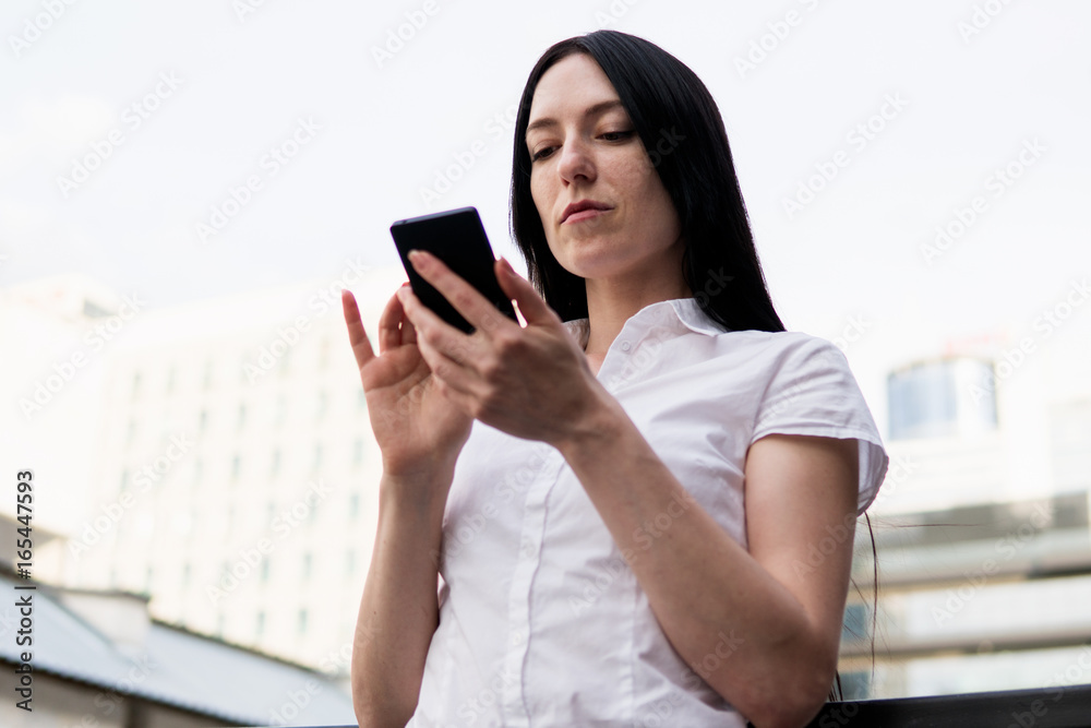 Successful business woman using smart phone in the city Successful business woman using smart phone in the city
