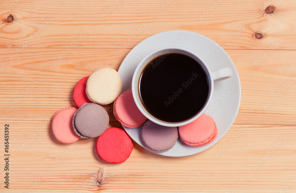 Obraz premium Cup of coffee with macaroons on wooden background