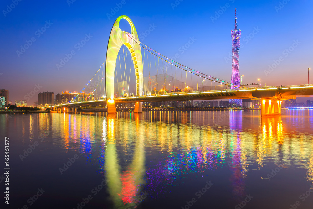 Naklejka premium Light show in sunset time at modern bridge in Zhujiang river and modern building of financial district in guangzhou city, China
