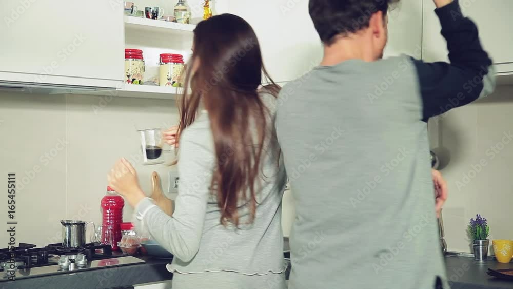 Couple drinking coffee and milk while dancing in kitchen Couple drinking coffee and milk while dancing in kitchen