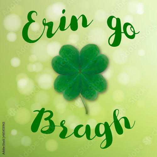 Erin go Bragh. Lettering typography with realistic four leaf clover on green bokeh background. photo