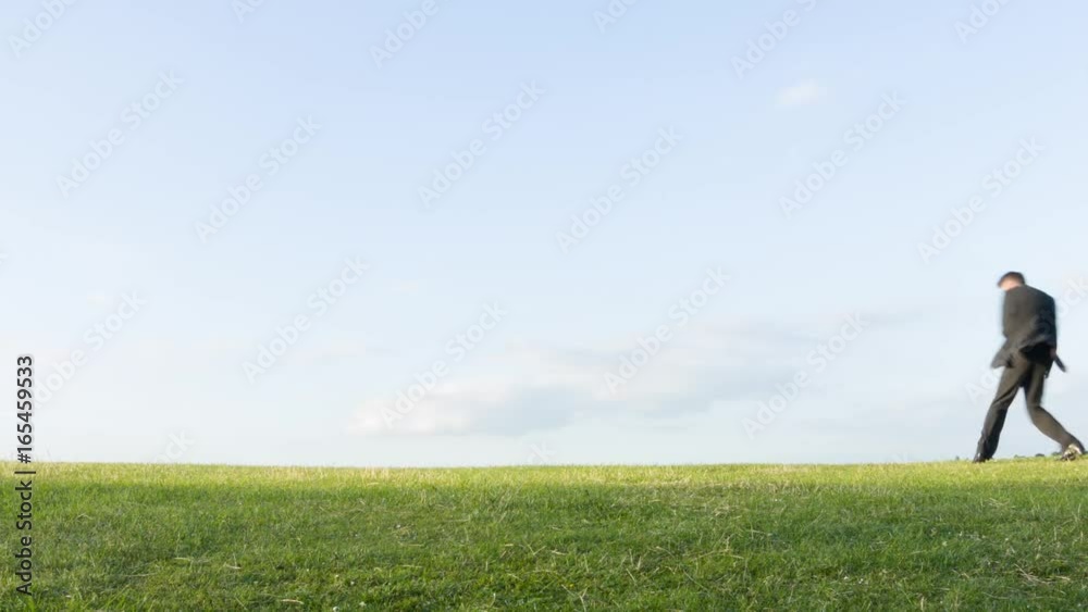 Happy carefree middle aged Caucasian businessman playing air guitar on a hill messing about daydreaming being a rock musician Happy carefree middle aged Caucasian businessman playing air guitar on a hill messing about daydreaming being a rock musician