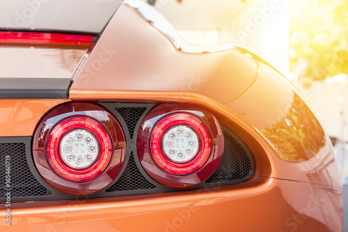 Back of an orange sport luxury car in sunset