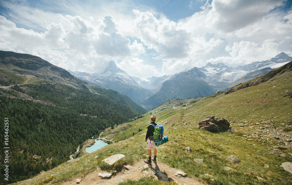 Man hiking to Matterhorn Mountain in summer in Zermatt city, Switzerland Man hiking to Matterhorn Mountain in summer in Zermatt city, Switzerland